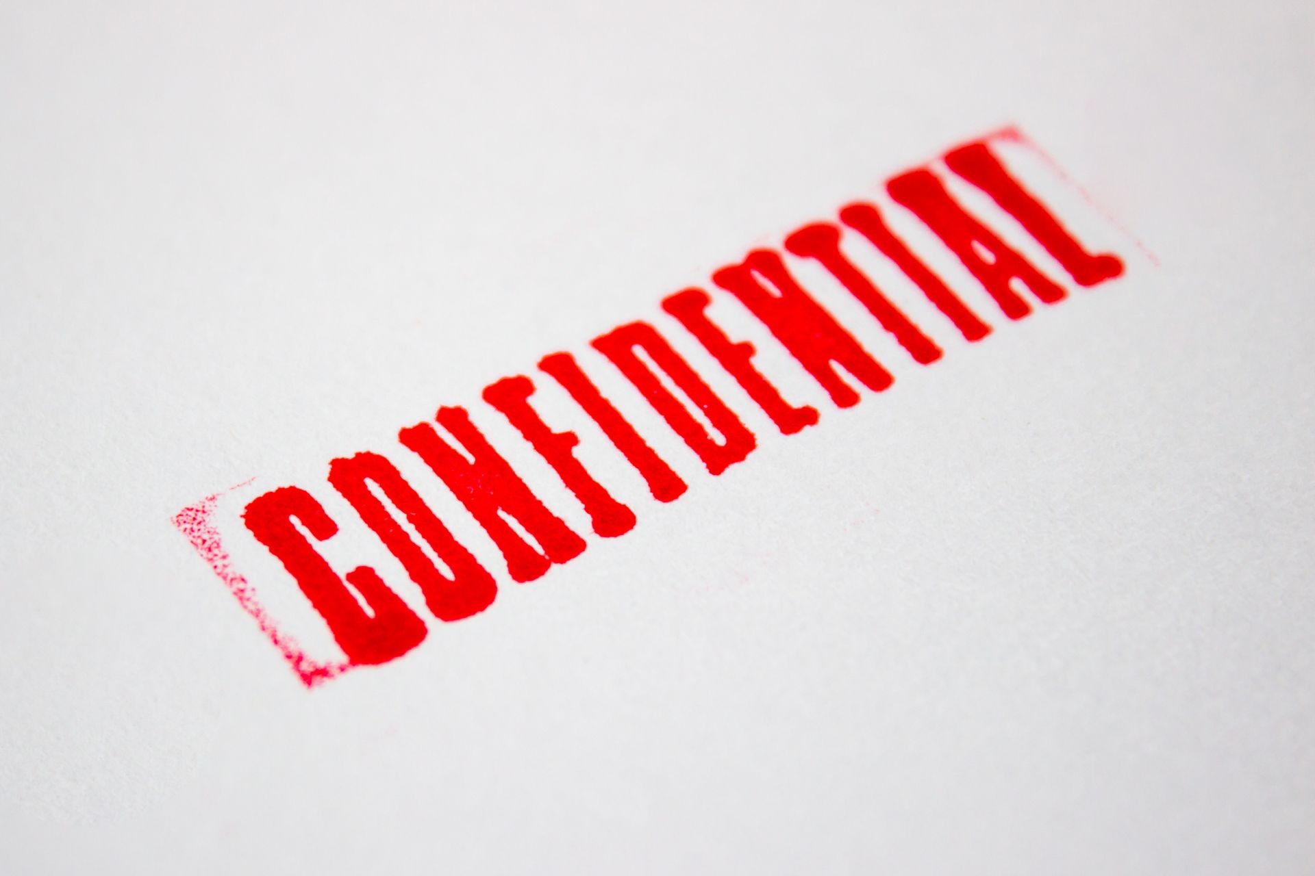 Red CONFIDENTIAL word grunge rubber stamp on white paper or document. Show top secret, Personal private and strictly confidential information, Document and business concept. Copy space for text.